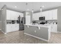 Modern kitchen with white cabinetry, stainless steel appliances, and a center island for food preparation at 3318 Current Ave, Winter Garden, FL 34787