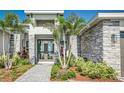 Close-up of the home's entry, featuring double doors and tropical plants at 839 Waterfern Trail Dr, Auburndale, FL 33823