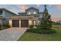 Beautiful two-story home with a two-car garage and manicured landscaping at dusk at 15820 Vetta Dr, Montverde, FL 34756