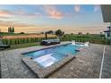 Beautiful outdoor swimming pool with jacuzzi and luxurious outdoor seating area overlooking the golf course at 15820 Vetta Dr, Montverde, FL 34756