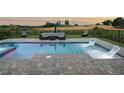 Relaxing backyard swimming pool and tanning ledge, including an outdoor seating area overlooking the golf course at 15820 Vetta Dr, Montverde, FL 34756