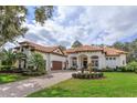 Stunning two-story home with a tile roof, palm trees, and a brick paved driveway at 6130 Blakeford Dr, Windermere, FL 34786