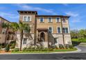 Attractive tan townhome with a Spanish-style tiled roof, landscaping, and walkway at 637 Pavia Loop, Lake Mary, FL 32746