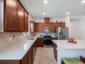 Well-equipped kitchen featuring stainless steel appliances, wood cabinets, and quartz countertops at 2542 Cliff Way, St Cloud, FL 34771