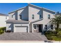 Two-story home with light-grey siding, stone accents, and a two-car garage at 1758 Oak Blossom Dr, Davenport, FL 33837