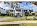 Modern home with a circular driveway and lush landscaping at 6000 Tarawood Dr, Orlando, FL 32819