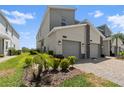 Exterior view features a two-car garage, stone accents, and tidy landscaping at 1065 Splash Shot Pl # 1801, Davenport, FL 33896