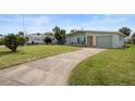 Front view of a single story home with a spacious driveway and landscaping at 36 Camellia Dr, Ormond Beach, FL 32176