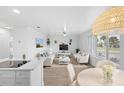 Bright and airy living room with white sofas and a large TV at 36 Camellia Dr, Ormond Beach, FL 32176