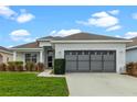 Single story home with gray garage door and well-manicured lawn at 145 Lewis Dr, Davenport, FL 33837