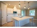 Spacious kitchen with white cabinets, large island, and stainless steel appliances at 1676 Andover Ridge Dr, Deland, FL 32720