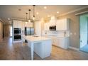 Modern kitchen boasting white cabinetry, a sizable island, and stainless steel appliances at 1676 Andover Ridge Dr, Deland, FL 32720