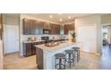 Modern kitchen with island, granite countertops, and dark brown cabinets at 1677 Andover Ridge Dr, Deland, FL 32720