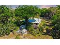 Aerial view of the home, showcasing a greenhouse, gazebo, lush landscaping, and mature trees in a private setting at 747 Center St, Ocoee, FL 34761