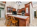 Kitchen featuring wood cabinets, granite countertops, tile flooring, an eat-in island, and stainless steel appliances at 747 Center St, Ocoee, FL 34761