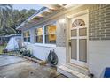 Charming home front entrance featuring a decorative door, gray brick siding, and landscaped garden at 1817 W Grant St, Orlando, FL 32805