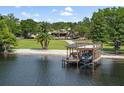 View of the boathouse at the water's edge featuring a covered boat lift, seating area, and ladder at 208 Green Lake Cir, Longwood, FL 32779