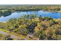 Aerial view shows a house on a waterfront property with lush landscaping at 39250 Forest Dr, Eustis, FL 32736