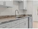 Updated kitchen with stainless steel appliances, white cabinets, and stone countertops at 4945 Sanoma Vlg # B, Orlando, FL 32808