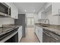 Updated kitchen featuring stainless steel appliances, stone countertops, and white cabinets at 4945 Sanoma Vlg # B, Orlando, FL 32808