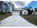 New construction home features a white exterior, driveway, and landscaping at 1112 Camden Way, Poinciana, FL 34758