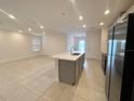 Open concept kitchen boasts a large island, gray cabinets, and stainless steel appliances at 1112 Camden Way, Poinciana, FL 34758