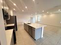 Modern kitchen with gray cabinets, quartz countertops, and stainless steel appliances at 1112 Camden Way, Poinciana, FL 34758