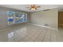 Bright living room featuring neutral walls, tile floors, a ceiling fan, and a large window at 759 Little Wekiva Cir, Altamonte Springs, FL 32714