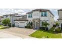 Two-story house, gray exterior, stone accents, three-car garage, and landscaped yard at 8042 Ludington Cir, Orlando, FL 32836