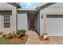 Inviting front entrance with a brick walkway, neat landscaping, and a stylish brown front door at 687 Campo Ln, Davenport, FL 33837