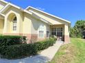 Charming home featuring a well-maintained lawn, brick accents, and an inviting front porch with comfortable seating at 2555 Oneida Loop, Kissimmee, FL 34747