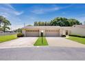 Charming condo featuring dual garage doors, well-manicured lawn, and beautiful landscaping at 2205 Cypress Cove Dr, Tavares, FL 32778