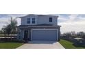 Two-story home with a two-car garage, showcasing a well-maintained lawn and landscaping at 5583 Maddie Dr, Haines City, FL 33845