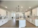 Modern white kitchen with an island, stainless steel appliances, and light wood floors at 124 Lake Dr, Oviedo, FL 32765