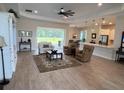 Open-concept living room featuring hardwood floors, bright lighting, and a view of the lanai at 3962 Kennebunk Loop, Mount Dora, FL 32757