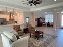 Spacious living room with wood-look tile flooring, modern lighting, and an open layout to the kitchen at 3962 Kennebunk Loop, Mount Dora, FL 32757