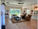 Open-concept living room with large windows, wood-look flooring and seamless access to the dining area at 3962 Kennebunk Loop, Mount Dora, FL 32757