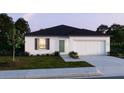 Charming single-story home featuring a two-car garage, a well-manicured lawn, and simple landscaping at 1445 General Mac Arthur Ave, Daytona Beach, FL 32114