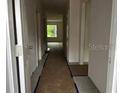 Hallway with view to the outdoors; shows construction progress on the flooring, walls, and door frames at 1445 General Mac Arthur Ave, Daytona Beach, FL 32114