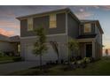 Two-story house with gray siding, two-car garage, and landscaping at 7367 Catania Loop, Clermont, FL 34714