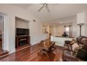 A living room has a ceiling fan, a leather sofa, and wood floors at 478 N Pin Oak Pl # 308, Longwood, FL 32779