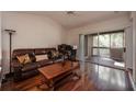 A living room shows a sliding door to a patio, a leather sofa, and wood floors at 478 N Pin Oak Pl # 308, Longwood, FL 32779