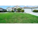 Charming home with lush lawn, complemented by vibrant flowerbeds and a convenient two-car garage at 2172 Nw 50Th Cir, Ocala, FL 34482