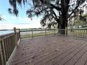 Inviting outdoor deck provides a serene waterfront view with a lake, big trees, and picturesque Spanish moss at 4790 Anderson Rd, Orlando, FL 32812
