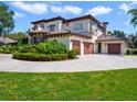 A large house with a three-car garage and manicured landscaping on a sunny day at 1911 Lake Markham Preserve Trl, Sanford, FL 32771