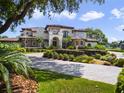 Stately Mediterranean home featuring manicured landscaping, a circular driveway, and a tiled roof at 1911 Lake Markham Preserve Trl, Sanford, FL 32771