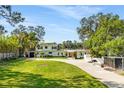 Beautiful two-story home with a large front yard, mature trees, and a long driveway leading to the garage at 1305 W Lake Mary Blvd, Lake Mary, FL 32746
