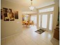 View of a tiled foyer, dining room, and glass paneled front door at 1201 Thornbury Ct, Winter Garden, FL 34787
