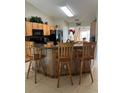 An open kitchen area with tiled floors, granite counters and wooden bar stools at 1201 Thornbury Ct, Winter Garden, FL 34787