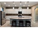 Bright kitchen features a granite island with seating, stainless steel appliances, and ample cabinet space at 251 Silver Maple Rd, Groveland, FL 34736